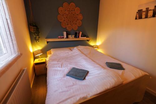 1 dormitorio con 1 cama con 2 toallas en Mooi huisje aan de Maas, en Op-Andel