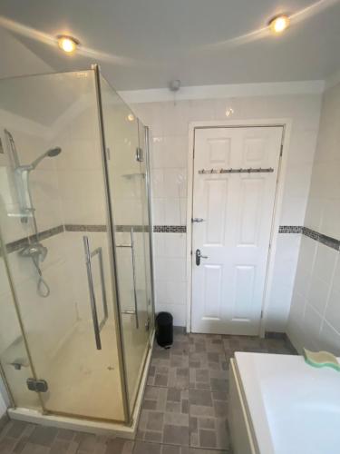 a bathroom with a shower and a glass door at Theldon in Luton