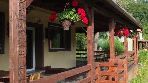 a porch of a house with flowers on it at Parkside Vila in Odorheiu Secuiesc
