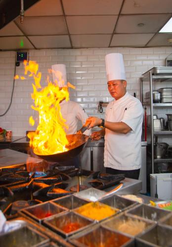 two chefs standing in a kitchen preparing food at Ramada Encore by Wyndham Kathmandu Thamel in Kathmandu