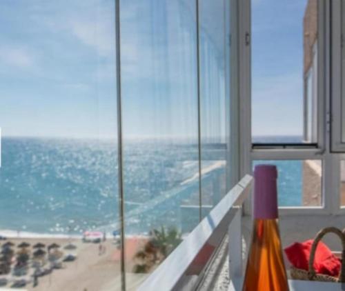a room with a view of a beach and the ocean at La duquesa in Fuengirola