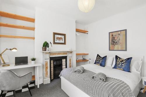 a bedroom with a bed and a desk and a chair at Stunning Victorian property near Canary Wharf! in London
