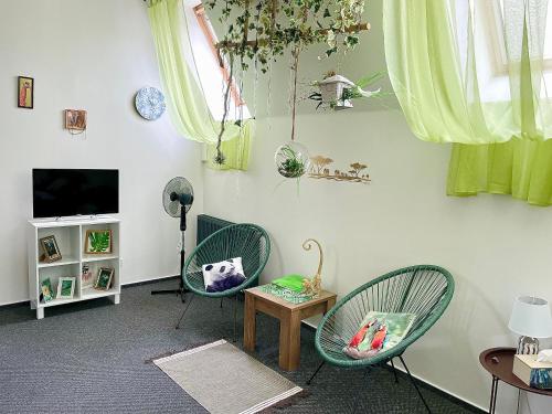 a living room with two chairs and a table and a tv at Penzion Villa Amélie in Mladá Boleslav