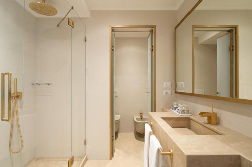 a bathroom with a sink and a toilet and a mirror at La Residenza Capri in Capri