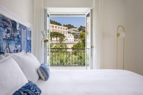 a bedroom with a bed and an open door to a balcony at La Residenza Capri in Capri