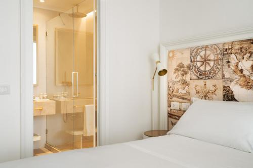 a bedroom with a white bed and a shower at La Residenza Capri in Capri