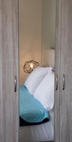 a bedroom with a bed with white pillows and a mirror at MELIKIRON LUXURY APARTMENTS in Agios Nikitas