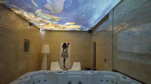 a bathroom with a tub with a fish painting on the ceiling at Resort EDEN domki, apartamenty i pokoje in Jastrzębia Góra