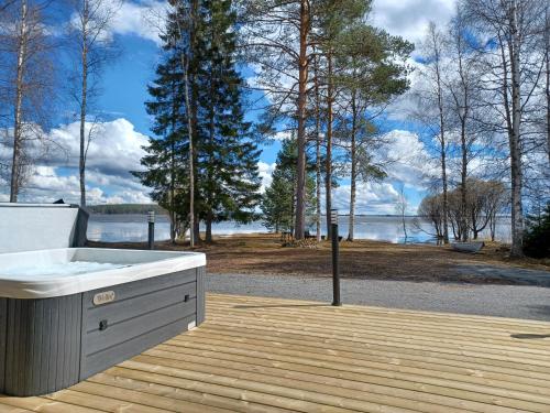 a bath tub on a deck with a view of the water at Söpölä in Alvajärvi
