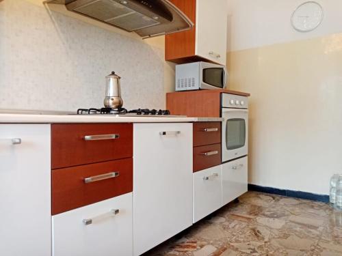 a kitchen with white cabinets and a stove top oven at Casa Vacanza! A 50m dal mare! in Bordighera
