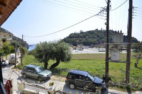 two cars parked in a parking lot next to a hill at Astacos Studios in Paleokastritsa