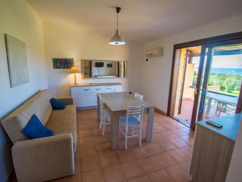 Residence Cala Petralana في بورتو بولو: مطبخ وغرفة معيشة مع طاولة وأريكة