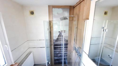 a glass shower in a room with a staircase at Domek Ewa in Giżycko