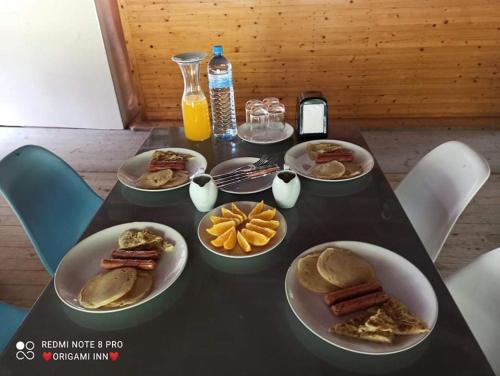 Una mesa negra con platos de comida encima. en Origami Inn Himandhoo, en Himandhoo 