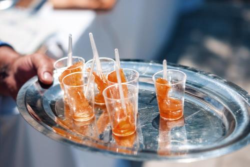 a tray with four glasses with orange liquid on it at Dreamy Stone House in Pesádha