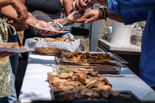 a group of people standing around a table with food at Dreamy Stone House in Pesádha