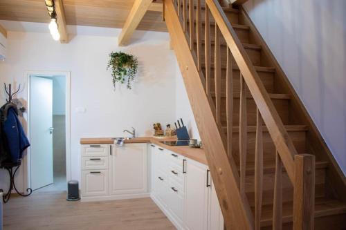 uma cozinha com armários brancos e uma escada de madeira em Rooms Močilnik em Begunje na Gorenjskem