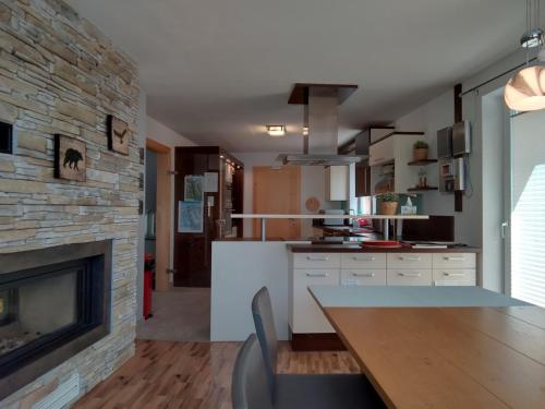 a kitchen with a fireplace and a dining table at Ferienhaus Skiblume in Oetz