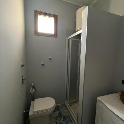 ein Bad mit einem WC, einer Dusche und einem Fenster in der Unterkunft Zà Lisa in San Vito lo Capo