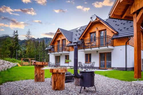 a log house with a fire pit in front of it at MM LUCKY apartments in Demanovska Dolina