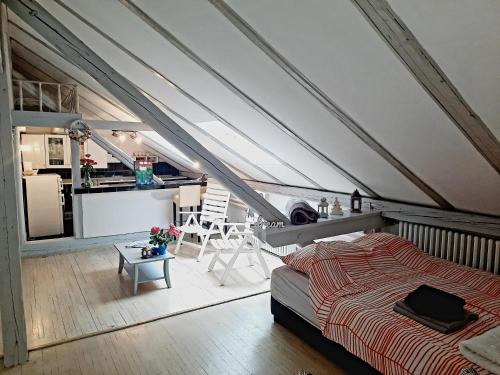 an attic bedroom with a bed and a kitchen at Deki & Kolet in Belgrade
