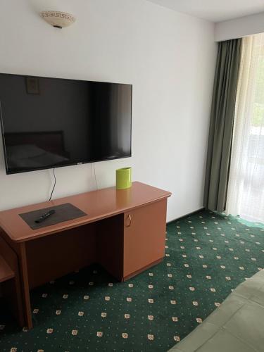 a desk in a room with a tv on the wall at Hotel-Restaurant Siesta Balea in Cumpăna