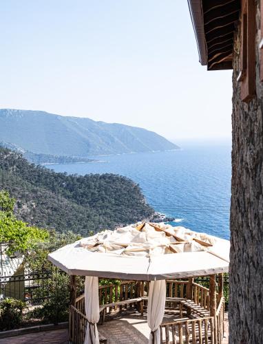 a table with umbrellas on a balcony overlooking the ocean at Casa Di Pietra in Fethiye