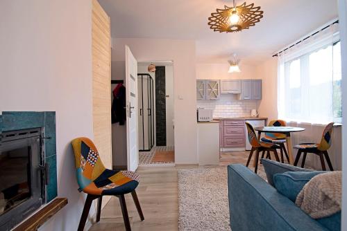 a living room with a couch and chairs and a table at Uroczy Apartament Muszynka in Muszynka