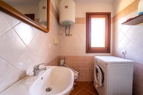 a bathroom with a sink and a washing machine at House in San Teodoro among the scents of Sardinia in San Teodoro