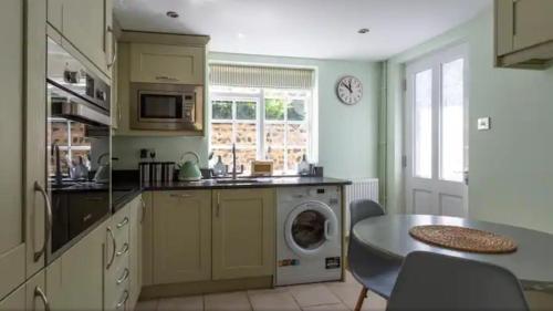 a kitchen with a washing machine and a table at The seaside retreat in Kent