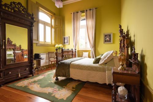 a bedroom with a bed and a large mirror at Palacete Villa Idalina in Caminha
