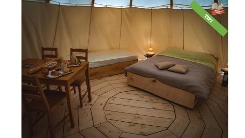 een slaapkamer met een bed en een tafel in een tent bij Woody Park in Fécamp