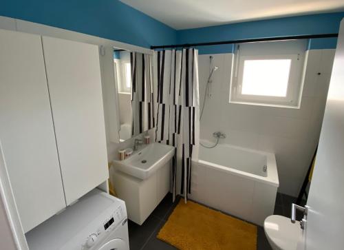 e bagno con lavandino, servizi igienici e vasca. di Brand New Cozy Apartment 10 min to city center a Vienna