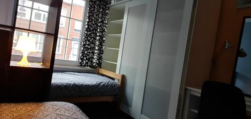 a small bedroom with a bed and a window at ROOM WITH 2 SEPARATED BEDS in Mortsel