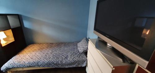 a small bedroom with a tv and a bed at ROOM WITH 2 SEPARATED BEDS in Mortsel