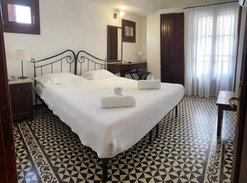a bedroom with a large bed with two white towels on it at Palazzo Arhontiko Apartments in Agios Nikolaos