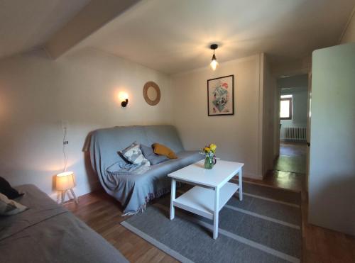 a living room with a couch and a table at Appartement avec vue sur le Sancy, parking gratuit in Le Mont-Dore