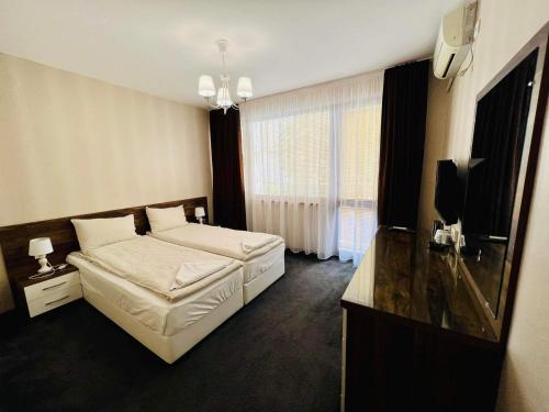 a bedroom with a bed and a flat screen tv at Джорджия in Kiten