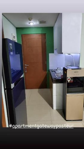 a kitchen with a brown door and a counter top at Apartment Gateway pasteur in Bandung