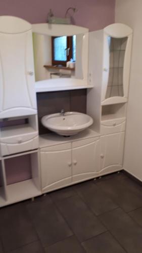 a white bathroom with a sink and a mirror at Ferienwohnung Bruni Bock in Itter