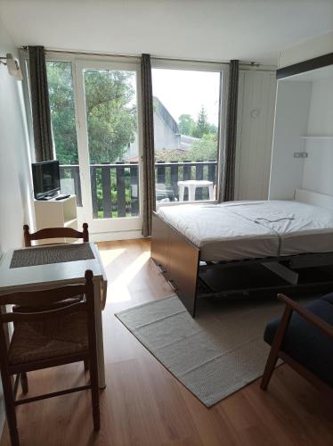une chambre avec un lit et une grande fenêtre dans l'établissement Studio tout confort au bord du lac d'Estey, à Dax