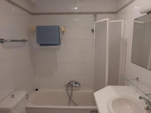 uma casa de banho com um chuveiro, uma banheira e um lavatório. em Apartment Noordhinder Westende em Middelkerke
