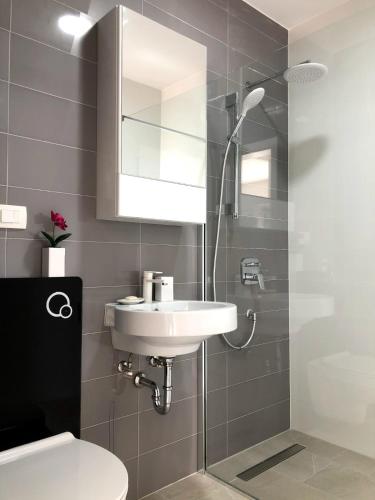 a bathroom with a sink and a mirror and a toilet at Apartments Amadea in Novi Vinodolski