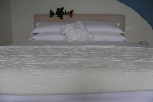 a large white bed with white sheets and pillows at Da Mariolino in Numana