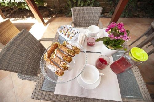 a table with a plate of food and flowers on it at Villa Maria Sofia in Realmonte
