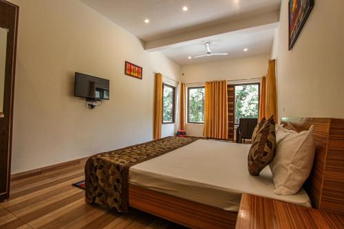 a bedroom with a large bed and a tv at Bajoon homestay in Bhīm Tāl