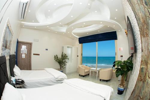 een slaapkamer met 2 bedden en uitzicht op de oceaan bij Nhar Accommodation House in Sohar