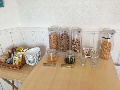 a wooden table with jars of nuts and other snacks at Westward B&B in Newquay