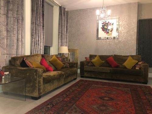 a living room with two couches and a rug at Ten Streets Bed & Breakfast in Liverpool