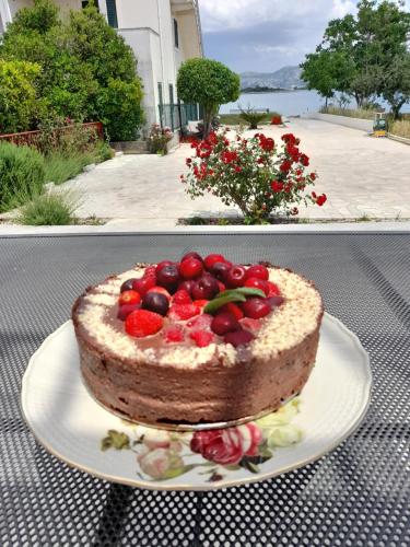 a chocolate cake with strawberries on a plate on a table at Apartmani Urlic in Sreser